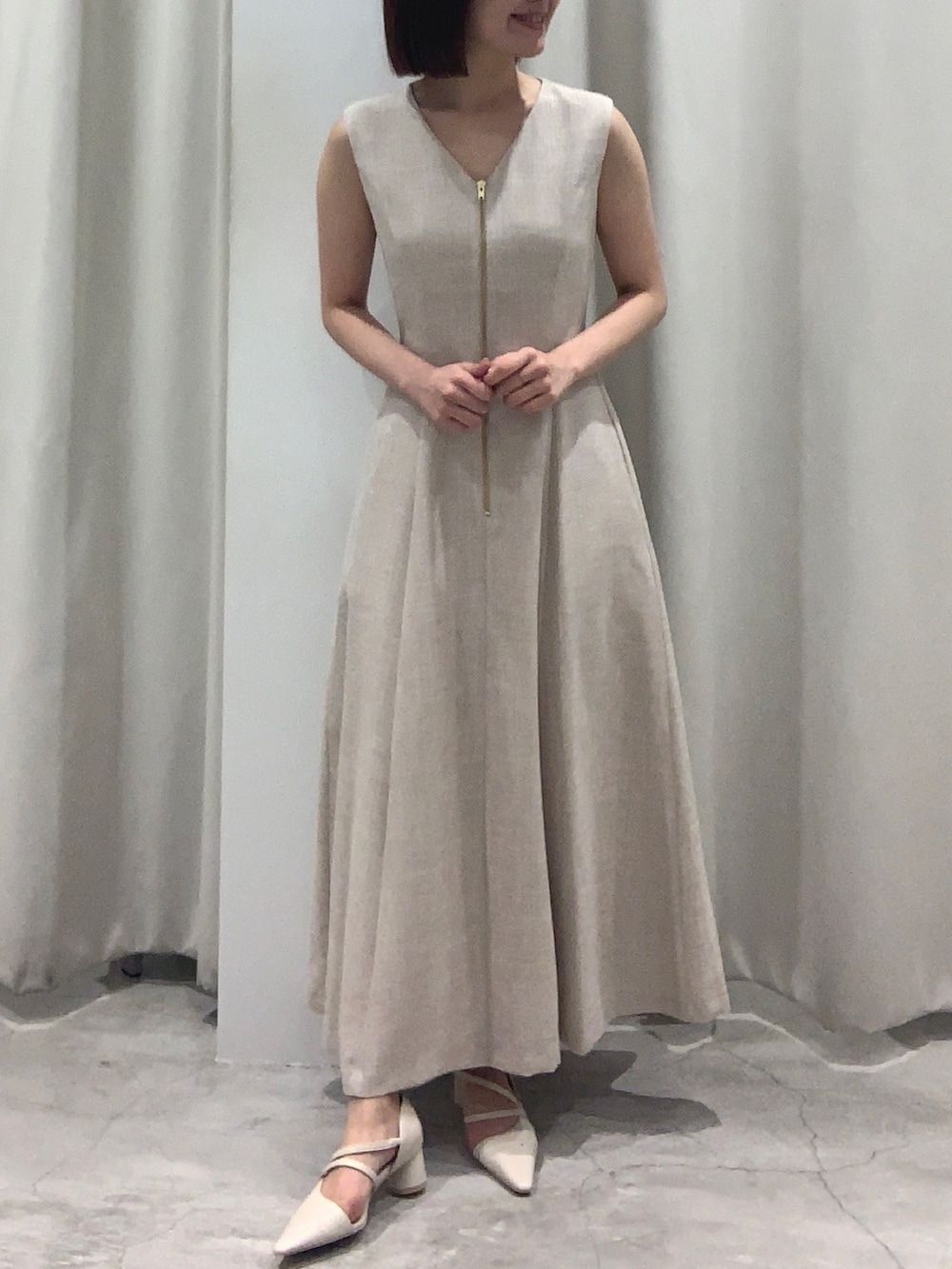 ベージュ系のワンピース、ホワイト系のショルダーバッグ、ホワイト系のパンプスを着用したレディースの夏コーディネートの6枚目の写真