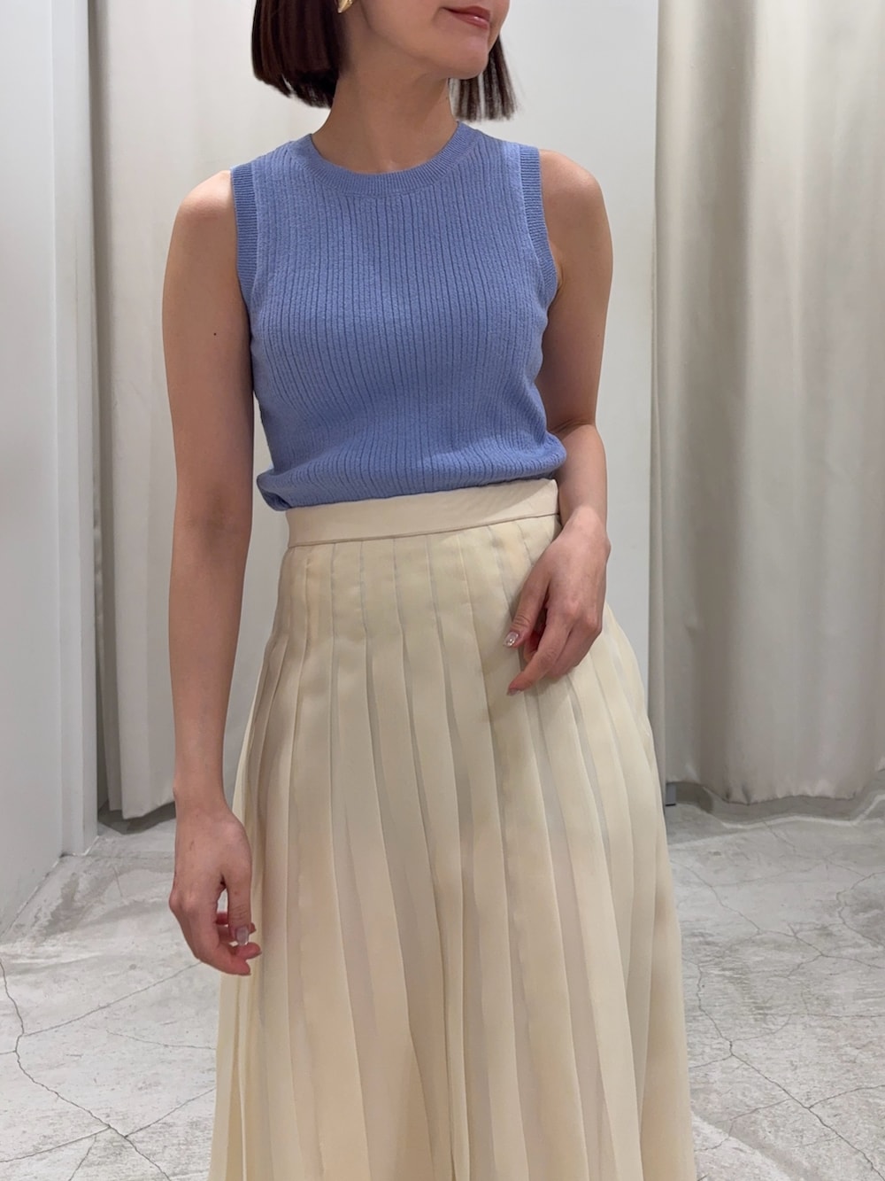 ブルー系のアンサンブル、ホワイト系のスカート、グレー系のスニーカーを着用したレディースの冬コーディネートの6枚目の写真