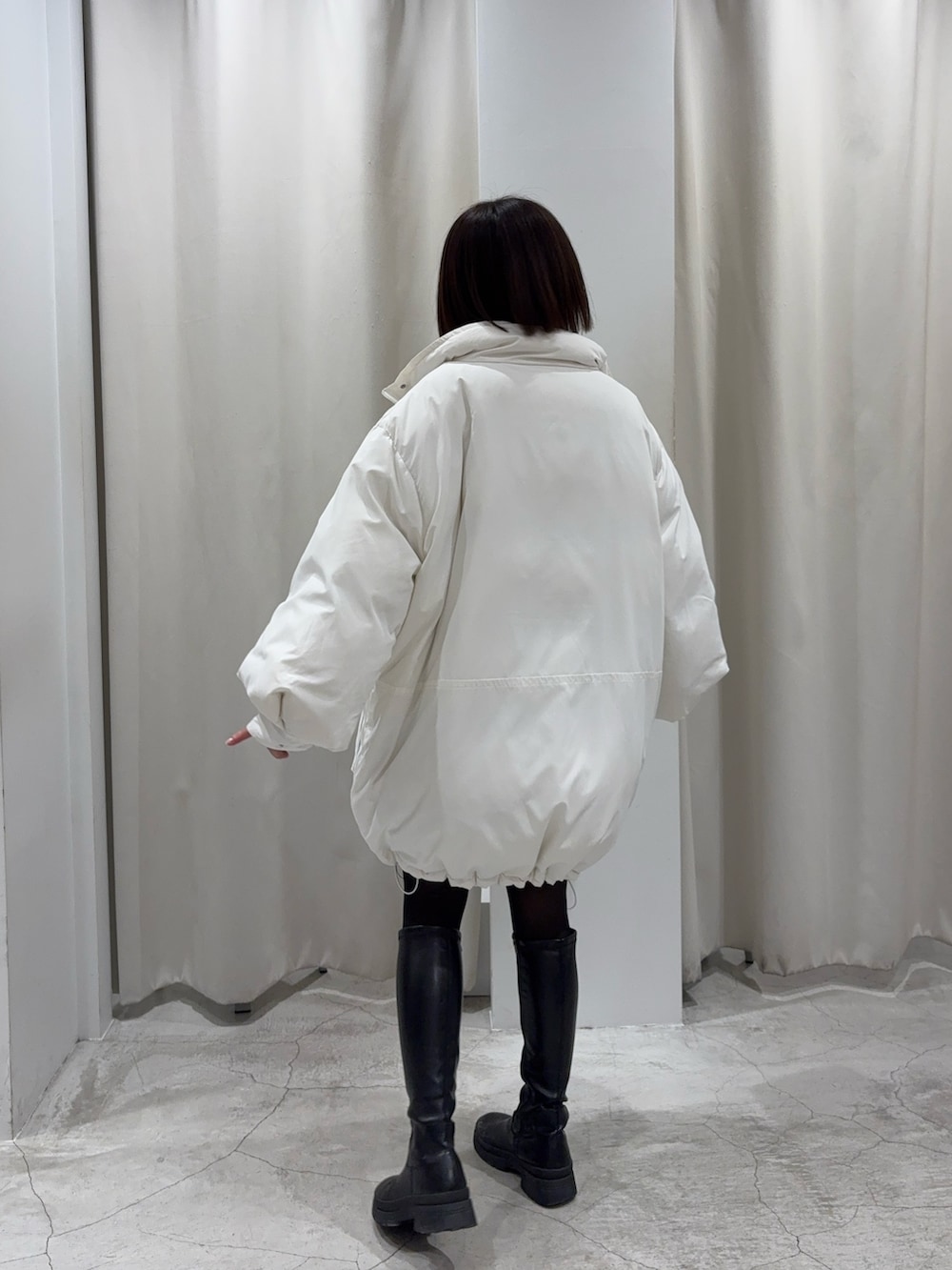 ブラック系のショルダーバッグ、グレー系のスカート、ホワイト系のダウンジャケット/コートを着用したレディースの冬コーディネートの4枚目の写真