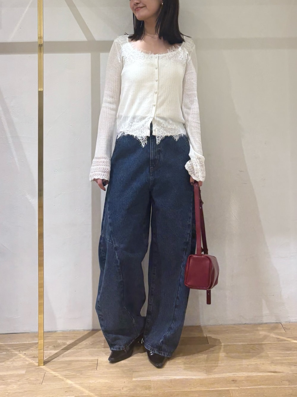 ホワイト系のカーディガン/ボレロ、ブルー系のデニムパンツ、レッド系のハンドバッグを着用したレディースの秋コーディネートの7枚目の写真