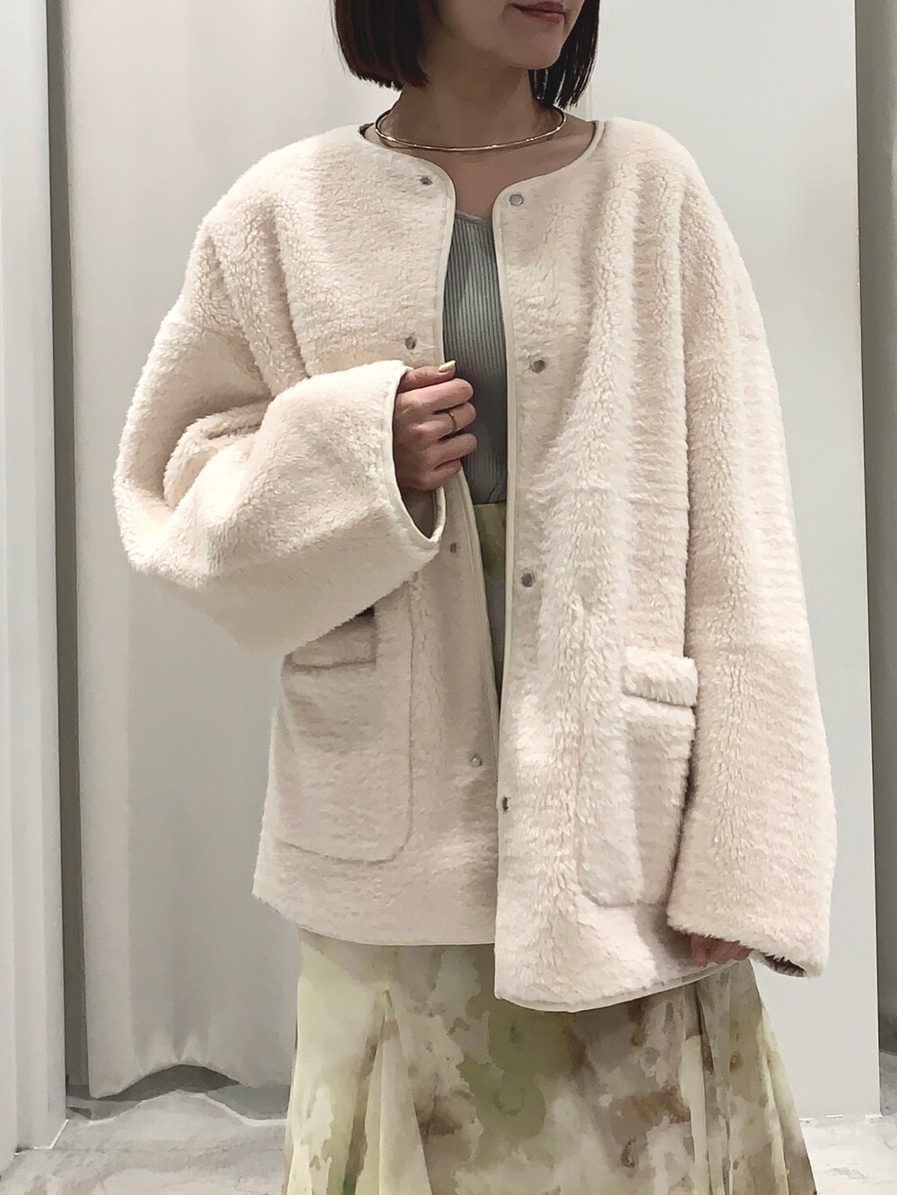 ホワイト系のブルゾン、イエロー系のスカート、グリーン系のニット/セーターを着用したレディースの夏コーディネートの3枚目の写真