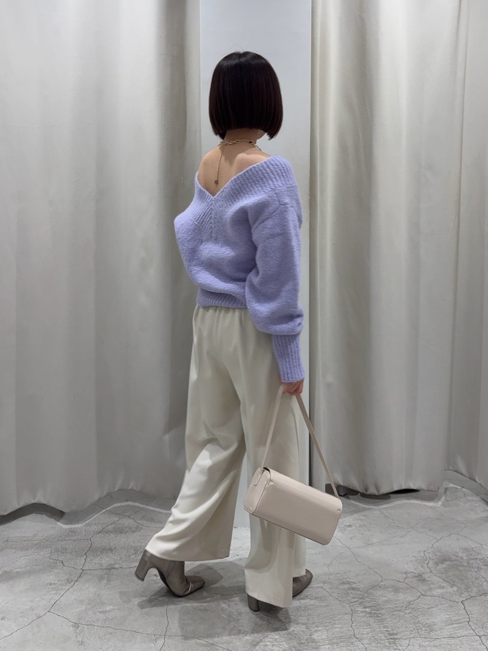 パープル系のニット/セーター、ホワイト系のその他パンツ、ホワイト系のショルダーバッグを着用したレディースの冬コーディネートの4枚目の写真