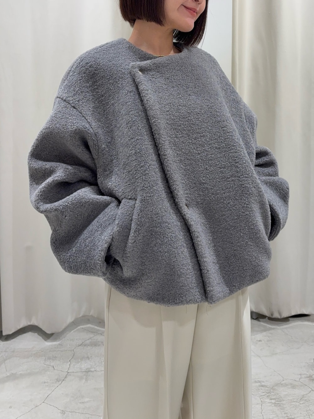 グリーン系のニット/セーター、グレー系のブルゾン、ホワイト系のその他パンツを着用したレディースの冬コーディネートの7枚目の写真