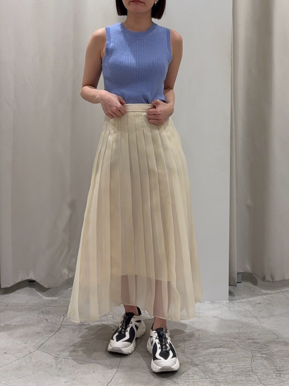 ブルー系のアンサンブル、ホワイト系のスカート、グレー系のスニーカーを着用したレディースの冬コーディネートの5枚目の写真