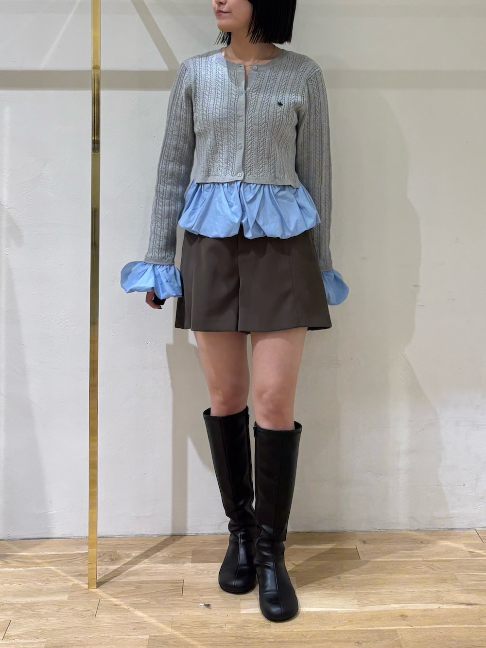 グレー系のニット/セーター、ブラウン系のその他パンツ、ブラック系のブーツを着用したレディースの秋コーディネートの5枚目の写真