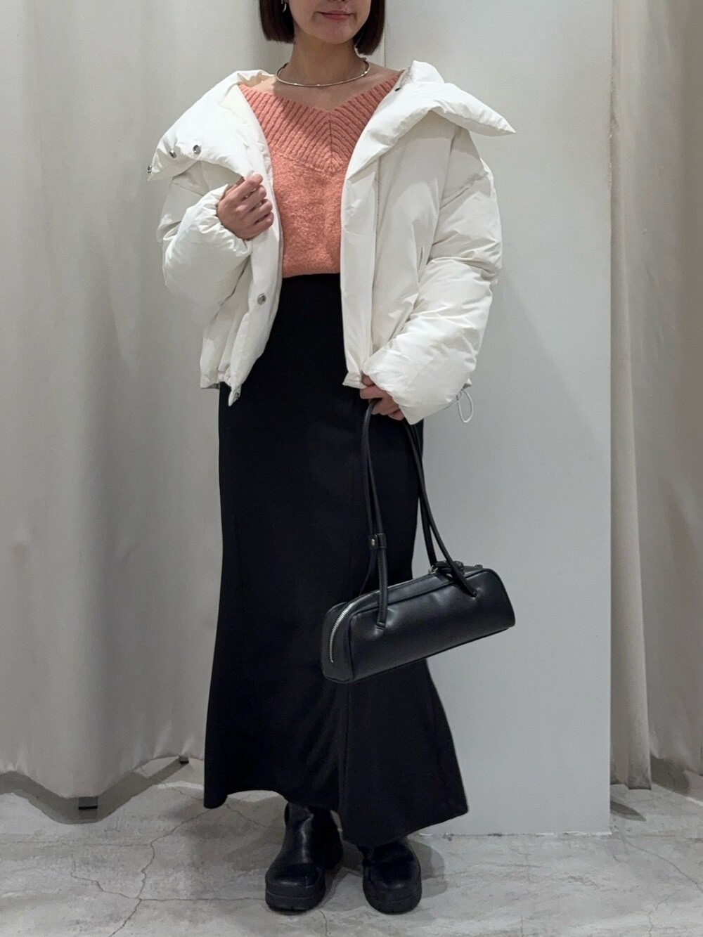 ブラック系のスカート、ピンク系のニット/セーター、ブラック系のショルダーバッグを着用したレディースの冬コーディネートの5枚目の写真