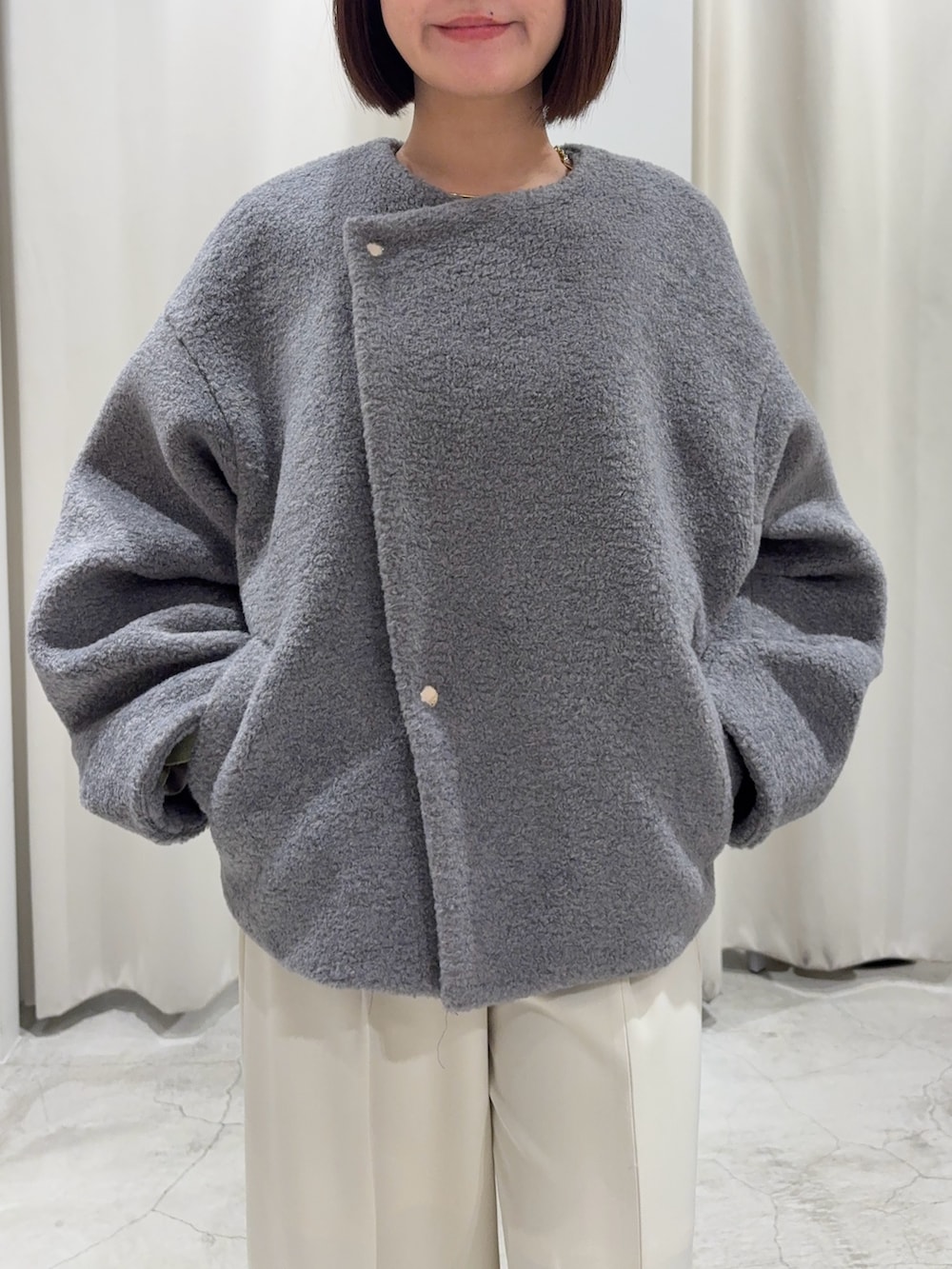 グリーン系のニット/セーター、グレー系のブルゾン、ホワイト系のその他パンツを着用したレディースの冬コーディネートの6枚目の写真