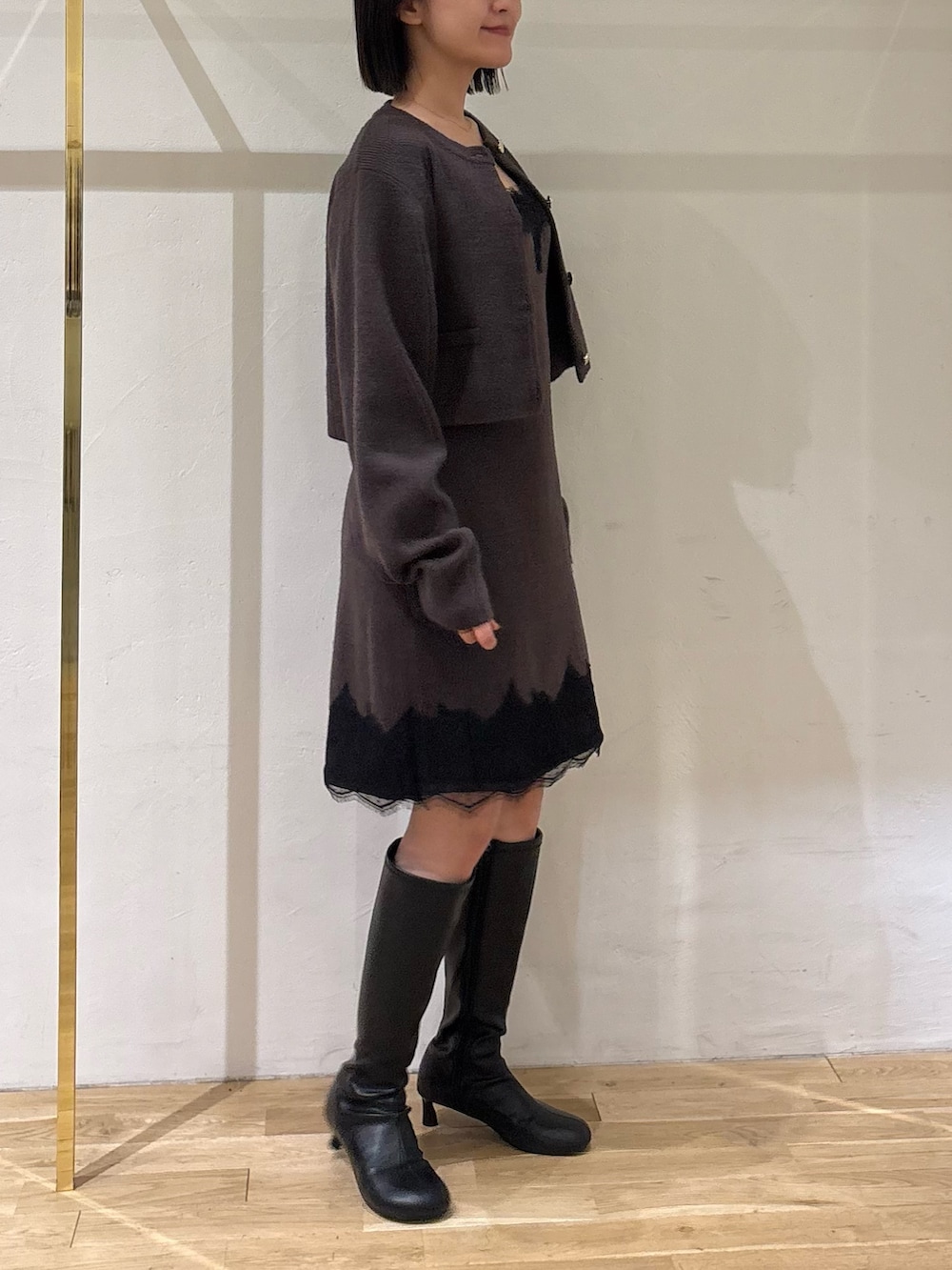 ブラウン系のワンピース、ブラック系のブーツを着用したレディースの秋コーディネートの3枚目の写真