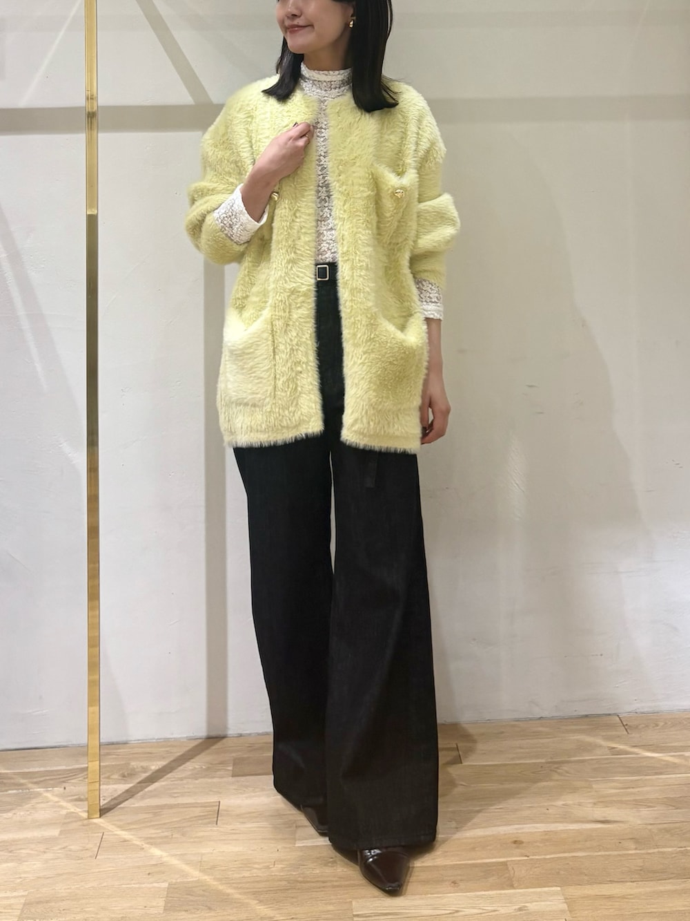 ブラック系のデニムパンツ、ホワイト系のTシャツ/カットソー、イエロー系のカーディガン/ボレロを着用したレディースの秋コーディネートの5枚目の写真