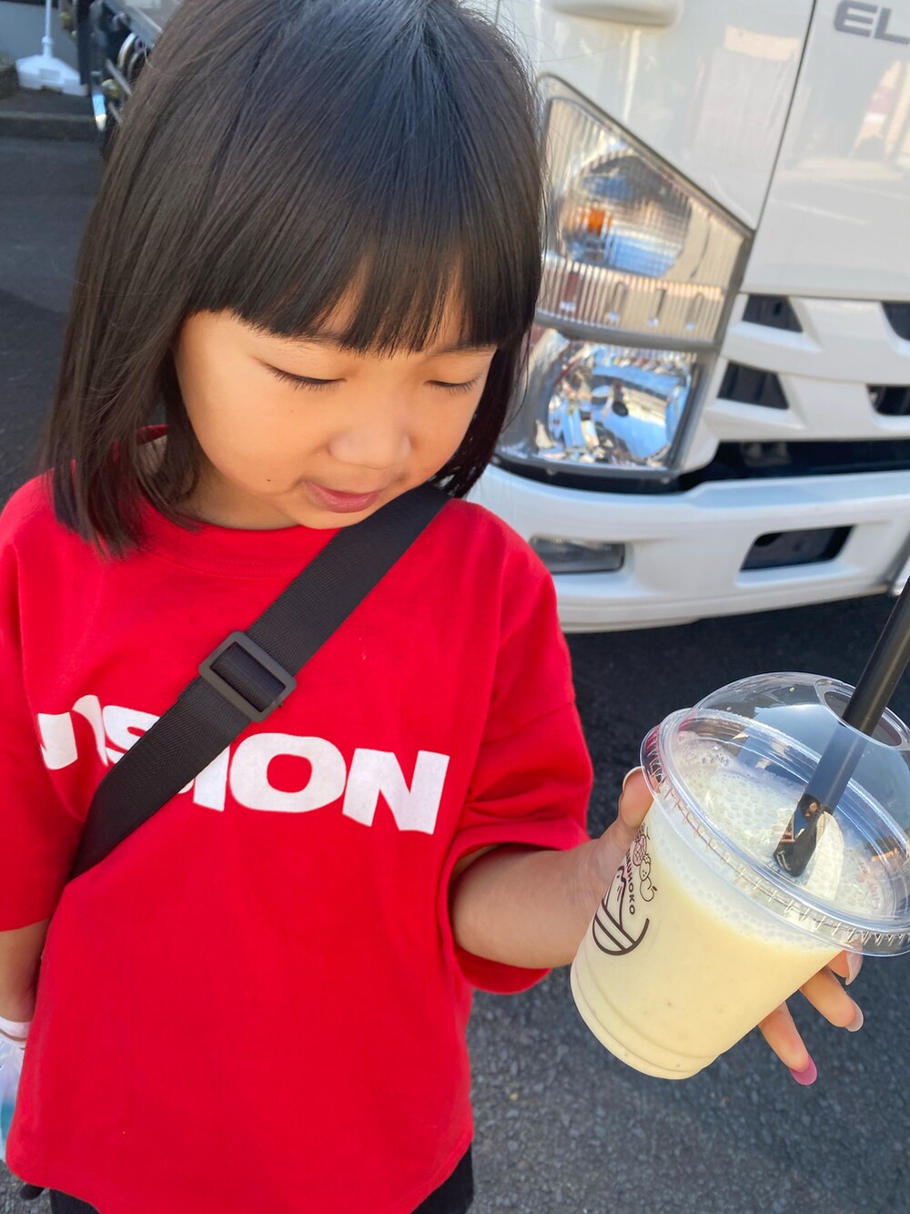 ホワイト系のTシャツ/カットソー、ブラック系のスカート、グレー系のスニーカーを着用したレディースの秋コーディネートの2枚目の写真