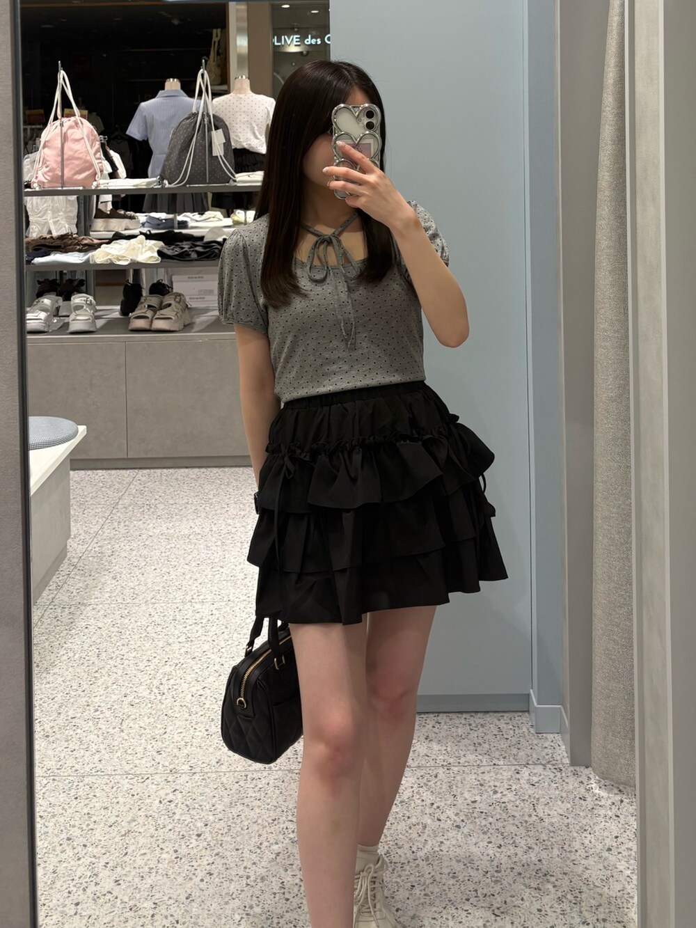 グレー系のTシャツ/カットソー、ブラック系のスカート、ブラック系のボストンバッグを着用したレディースの夏コーディネートの2枚目の写真