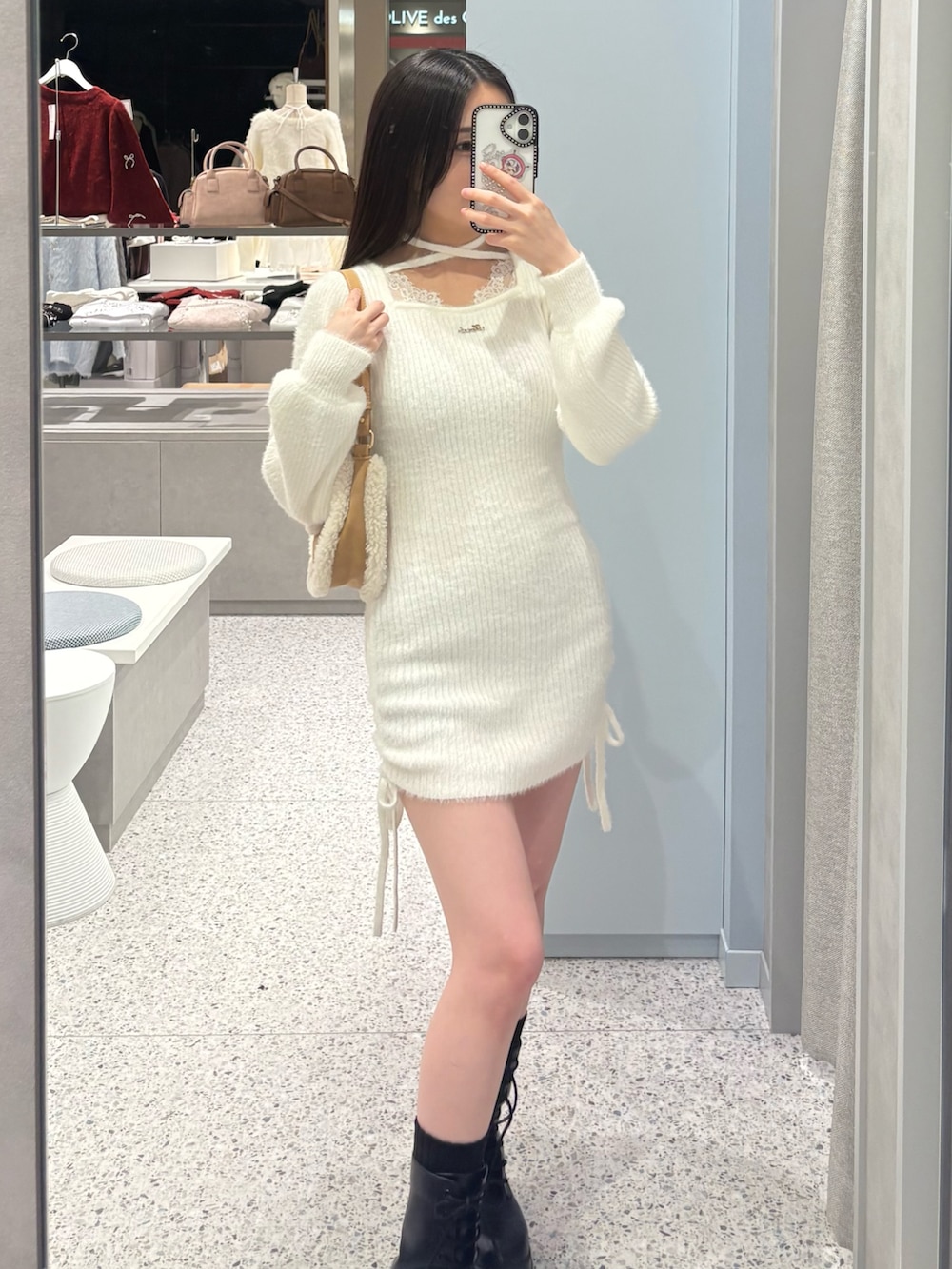 ホワイト系のワンピース、イエロー系のショルダーバッグ、ブラック系のブーツを着用したレディースの冬コーディネートの2枚目の写真