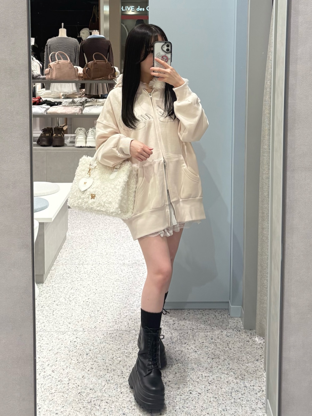 ピンク系のパーカー、ホワイト系のスカートを着用したレディースの冬コーディネートの2枚目の写真