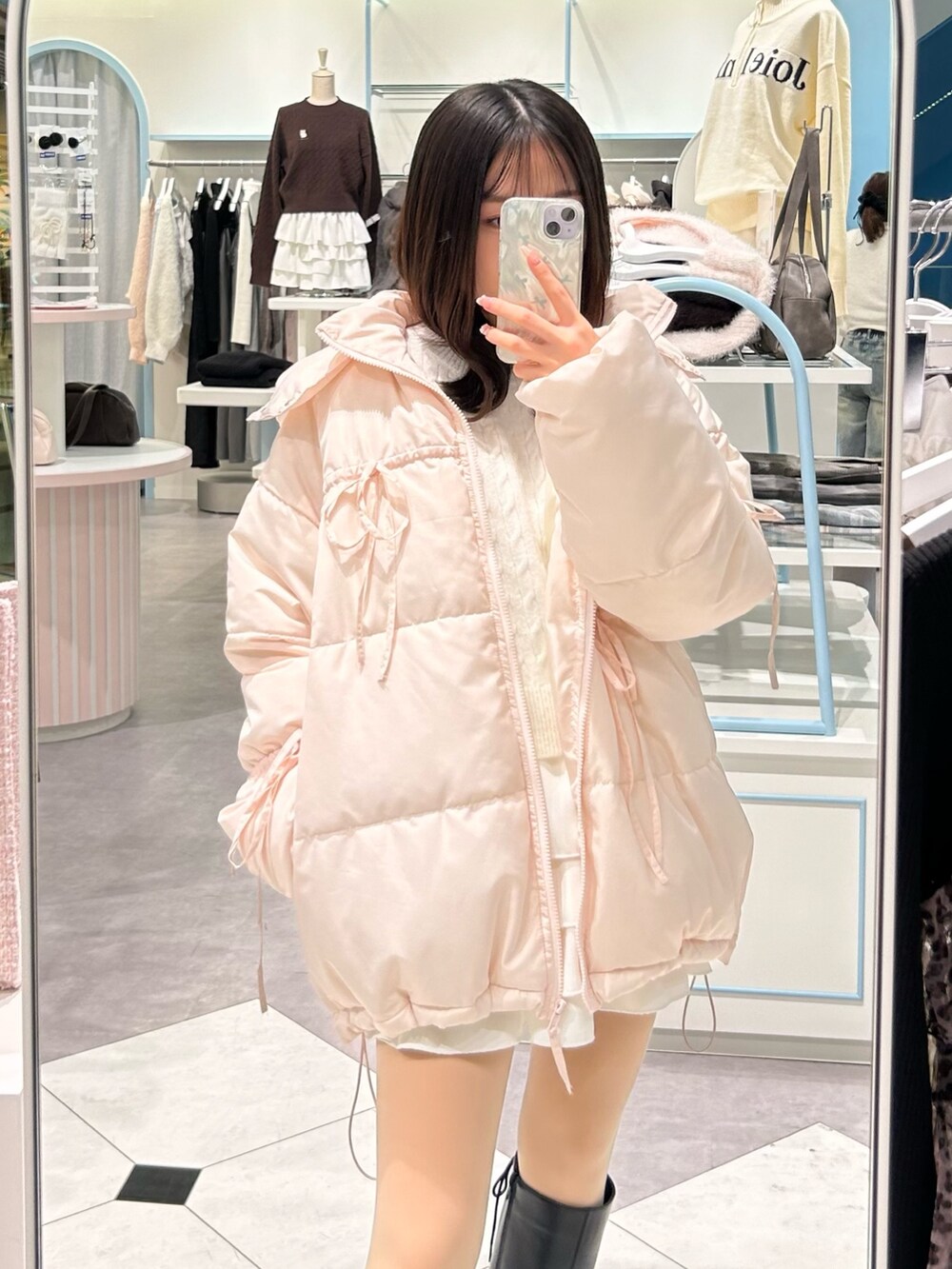 ホワイト系のスカート、ホワイト系のニット/セーター、ピンク系のダウンジャケット/コートを着用したレディースの冬コーディネートの2枚目の写真