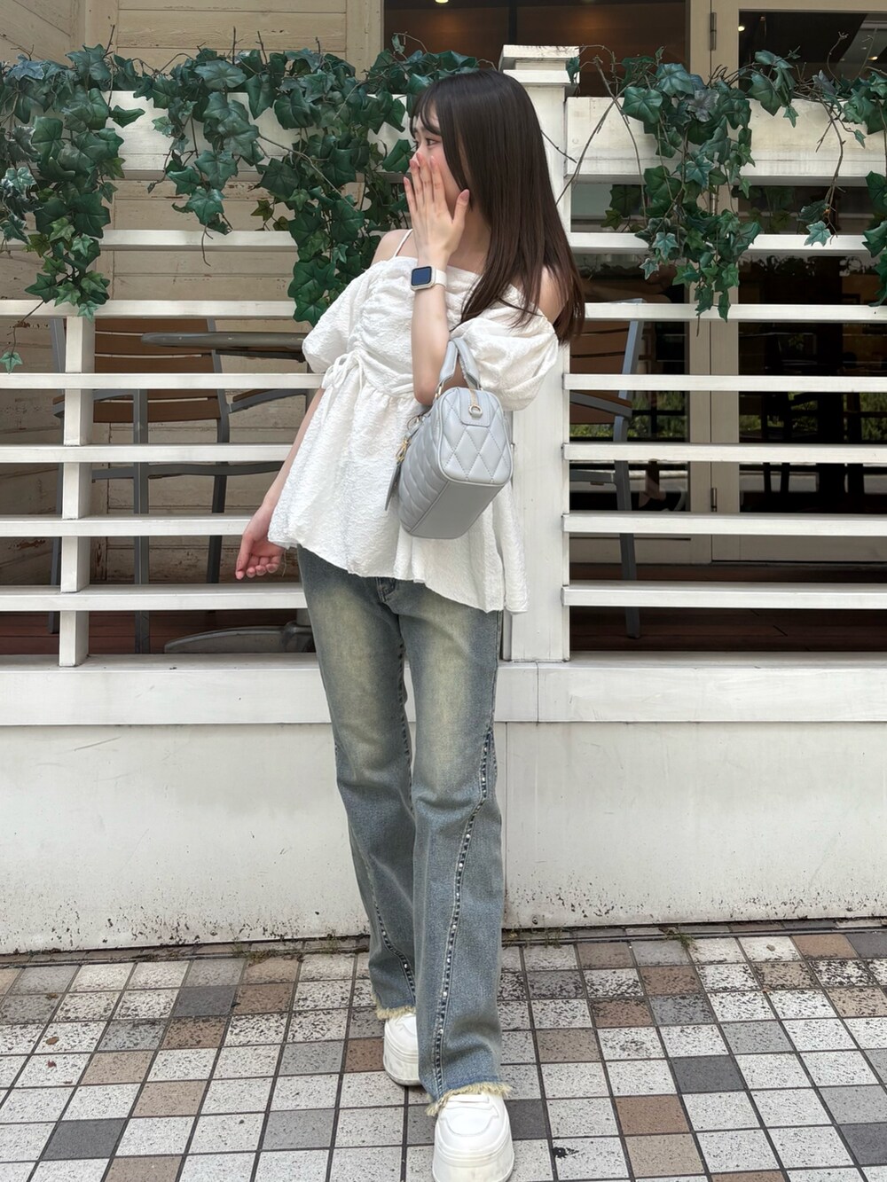 ブルー系のデニムパンツ、ホワイト系のシャツ/ブラウス、グレー系のボストンバッグを着用したレディースの夏コーディネートの2枚目の写真