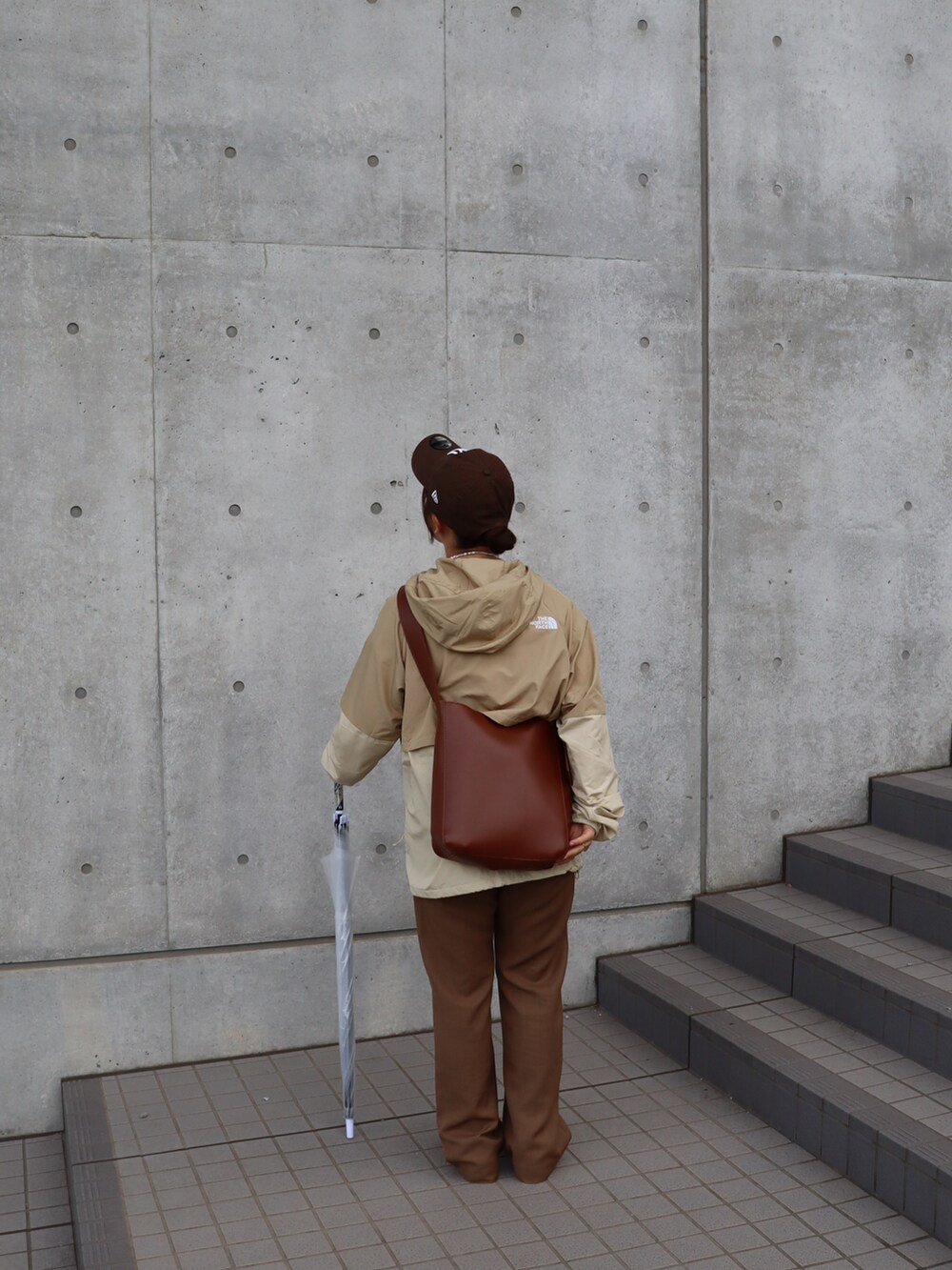 ブラウン系のその他パンツ、ベージュ系のスニーカー、ベージュ系のナイロンジャケットを着用したレディースの秋コーディネートの2枚目の写真