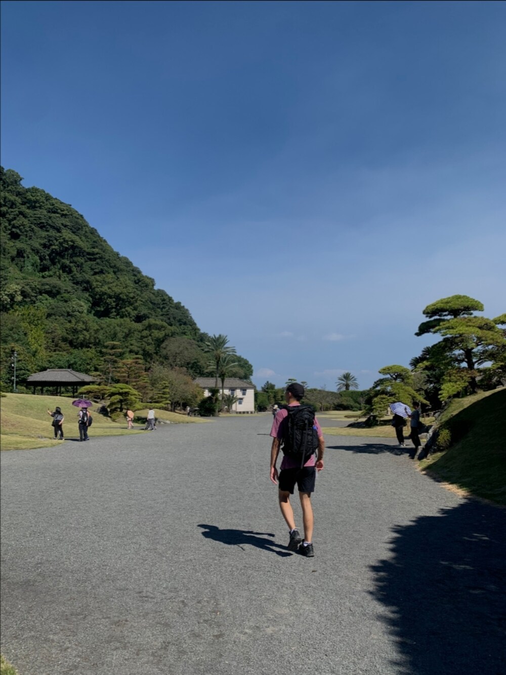 ピンク系のTシャツ/カットソー、ブラック系のバックパック/リュック、ブラック系のキャップを着用したメンズの秋コーディネートの2枚目の写真