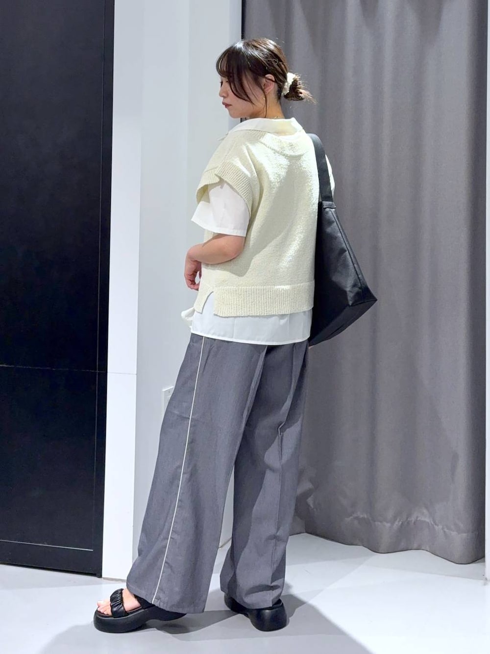 グレー系のスラックス、ブラック系のサンダル、ブラック系のショルダーバッグを着用したレディースの夏コーディネートの4枚目の写真