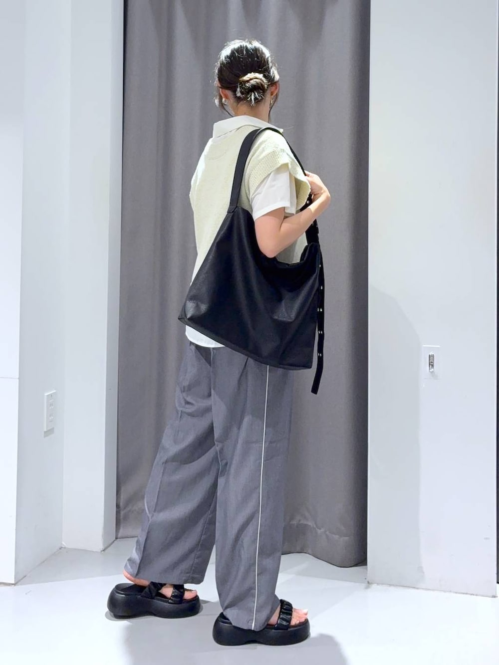 グレー系のスラックス、ブラック系のサンダル、ブラック系のショルダーバッグを着用したレディースの夏コーディネートの5枚目の写真