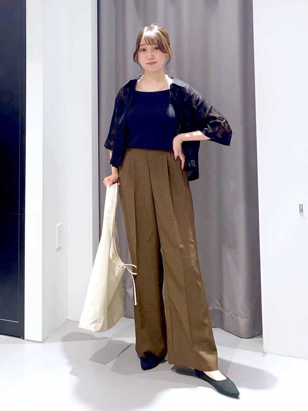 ホワイト系のトートバッグ、ブラック系のシャツ/ブラウス、ブラウン系のその他パンツを着用したレディースの春コーディネートの2枚目の写真