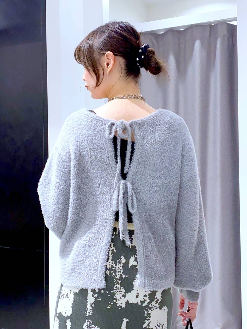 グレー系のスカート、ブラック系のブーツ、ブラック系のショルダーバッグを着用したレディースの秋コーディネートの5枚目の写真