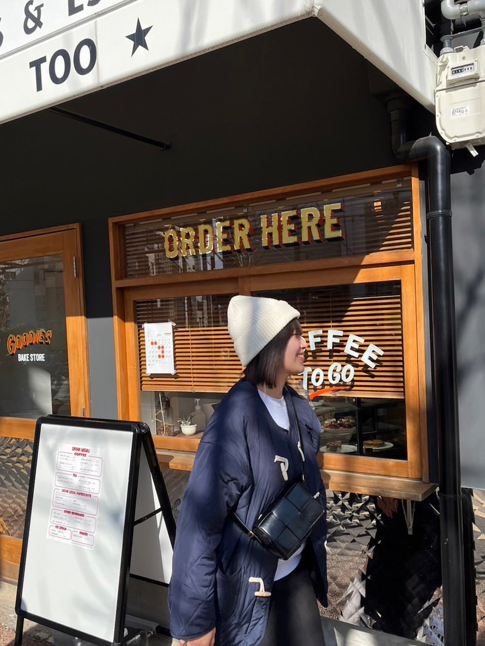 ブルー系のダウンジャケット/コート、ブラック系のショルダーバッグ、ブラック系のスカートを着用したレディースの冬コーディネートの2枚目の写真