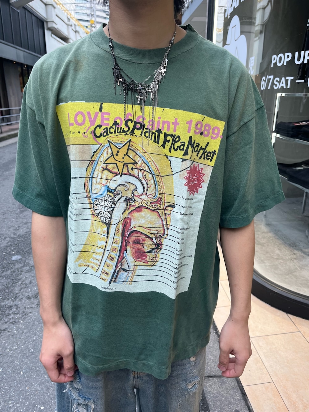 グリーン系のTシャツ/カットソー、ブルー系のデニムパンツを着用したメンズの夏コーディネートの3枚目の写真