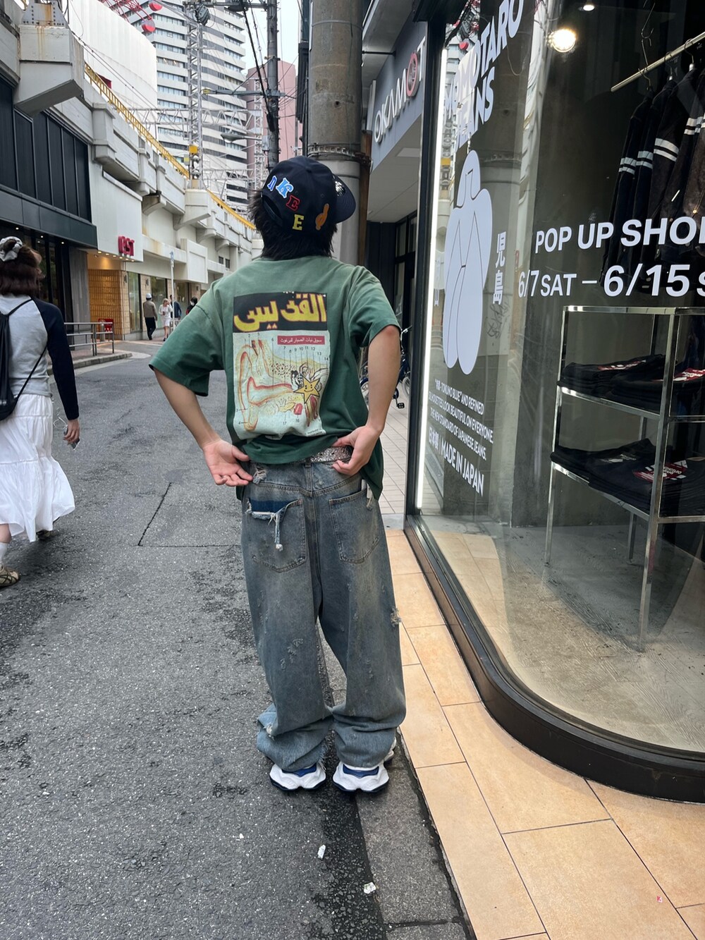 グリーン系のTシャツ/カットソー、ブルー系のデニムパンツを着用したメンズの夏コーディネートの2枚目の写真