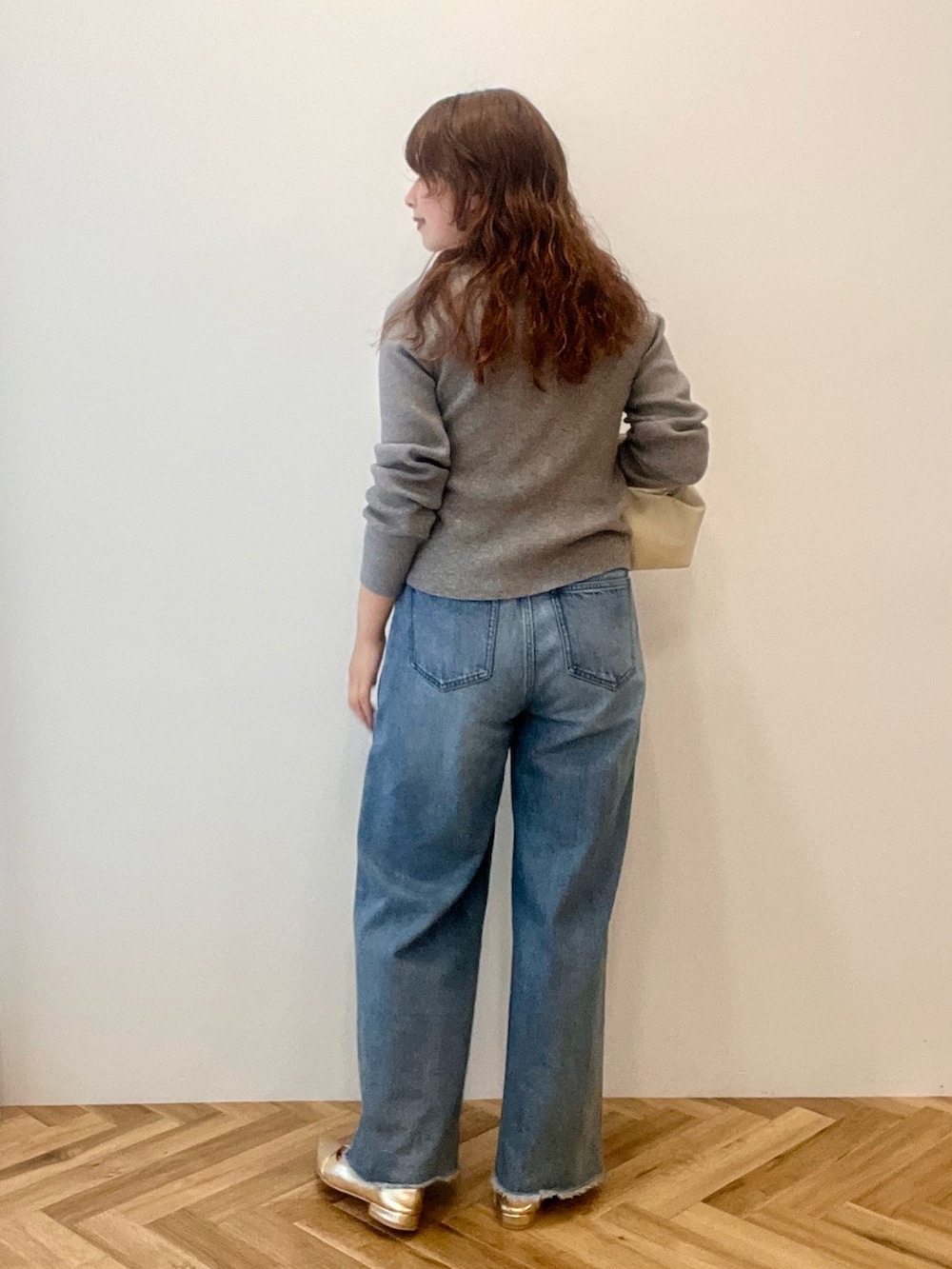 ブルー系のデニムパンツ、グレー系のニット/セーターを着用したレディースの秋コーディネートの2枚目の写真
