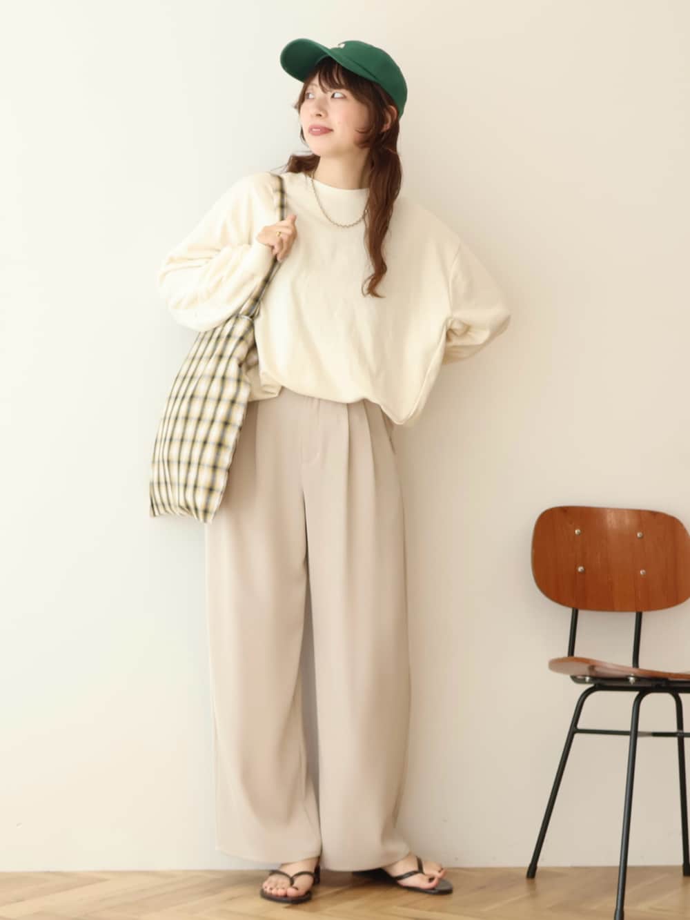 ホワイト系のスウェット、グリーン系のキャップを着用したレディースの春コーディネートの2枚目の写真