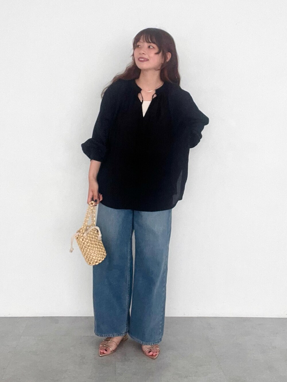 ブルー系のデニムパンツ、ブラック系のシャツ/ブラウスを着用したレディースの秋コーディネートの2枚目の写真