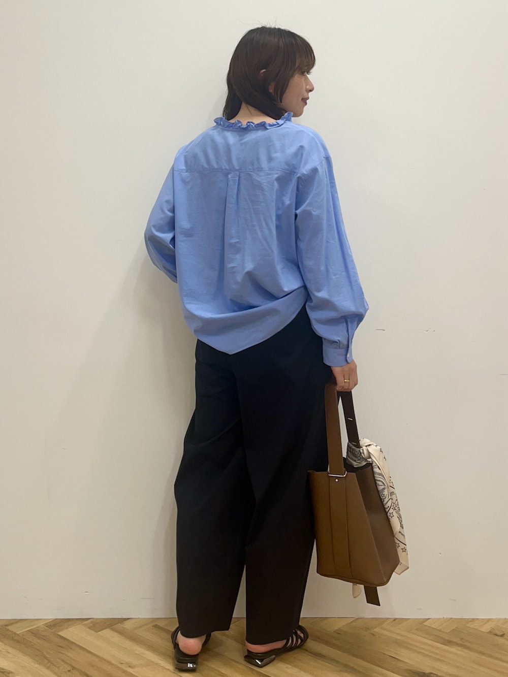 ブルー系のシャツ/ブラウス、ブラック系のその他パンツ、ブラウン系のショルダーバッグを着用したレディースの冬コーディネートの4枚目の写真