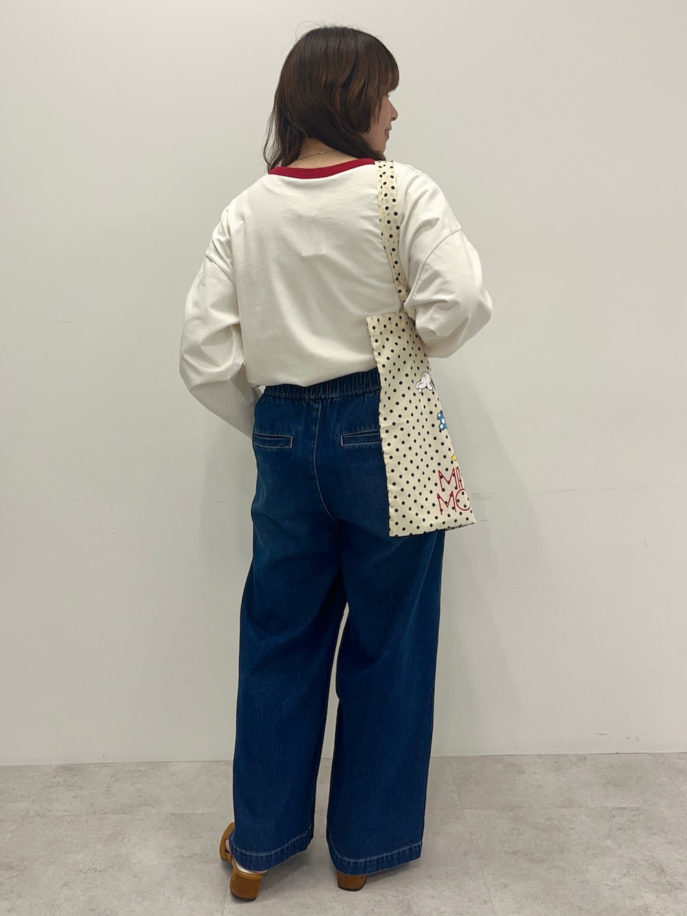 ホワイト系のTシャツ/カットソー、ブルー系のデニムパンツ、ホワイト系のトートバッグを着用したレディースの冬コーディネートの3枚目の写真