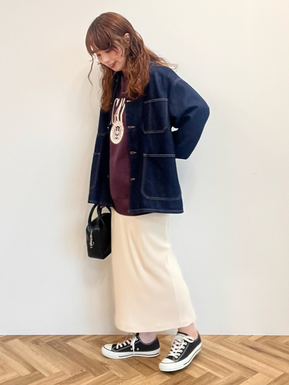 ブラウン系のスウェット、ブルー系のデニムジャケット、ホワイト系のスカートを着用したレディースの秋コーディネートの2枚目の写真