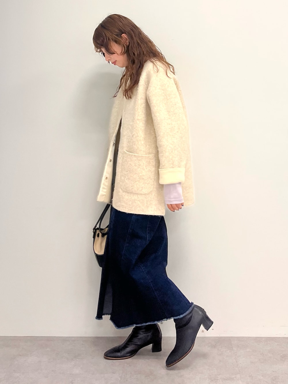 ブルー系のスカート、ベージュ系のカーディガン/ボレロ、パープル系のTシャツ/カットソーを着用したレディースの秋コーディネートの2枚目の写真