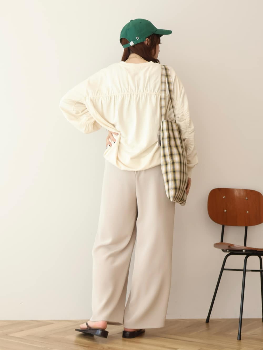 ホワイト系のスウェット、グリーン系のキャップを着用したレディースの春コーディネートの4枚目の写真