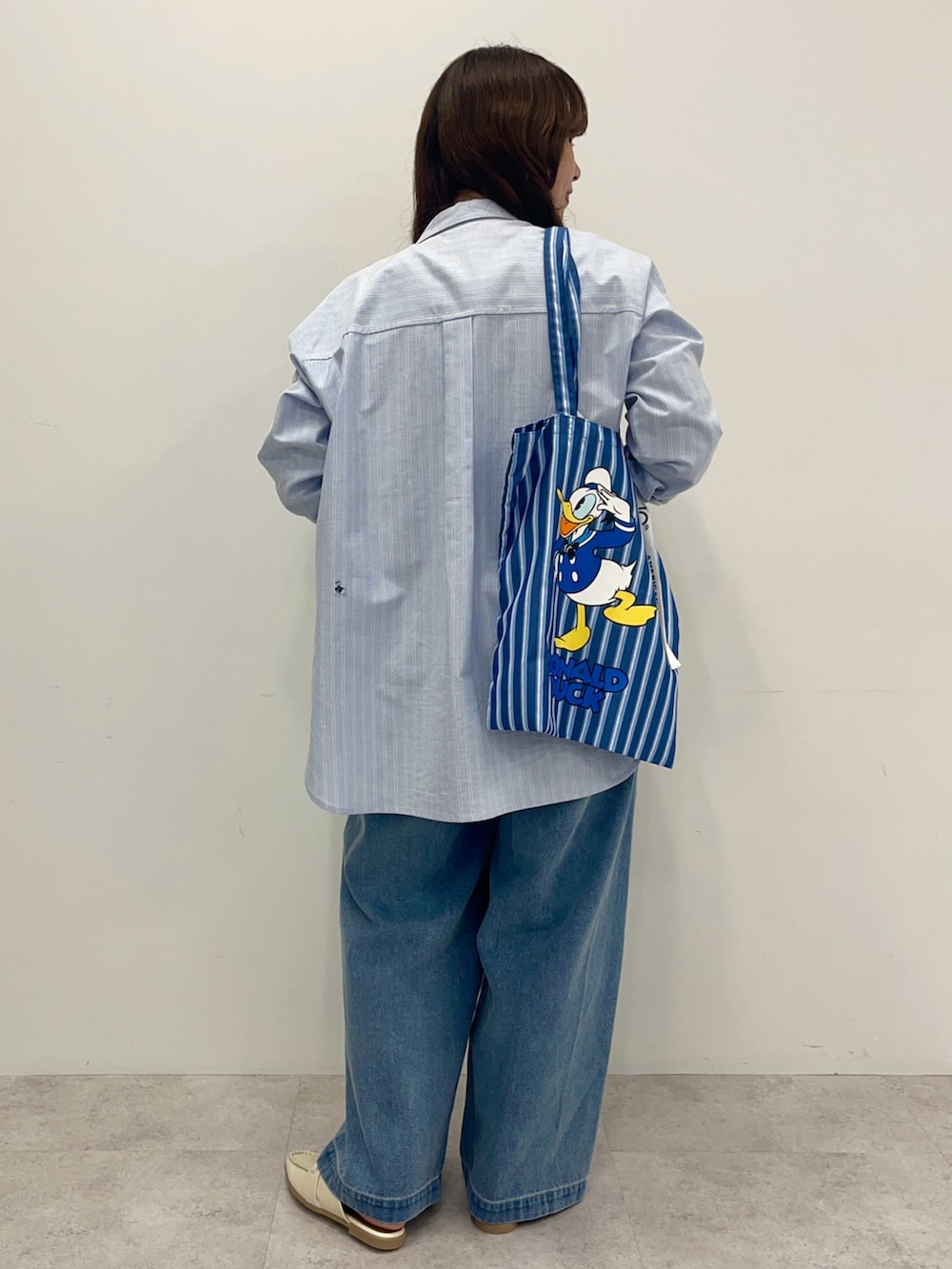 ブルー系のシャツ/ブラウス、ブルー系のデニムパンツ、ブルー系のトートバッグを着用したレディースの冬コーディネートの3枚目の写真