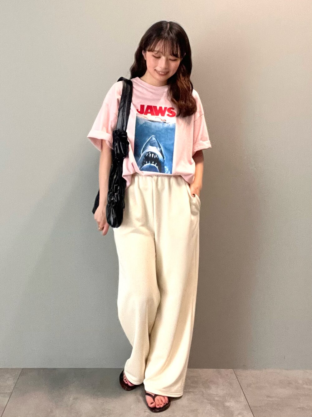 ホワイト系のその他パンツ、ピンク系のTシャツ/カットソー、ブラック系のショルダーバッグを着用したレディースの春コーディネートの2枚目の写真