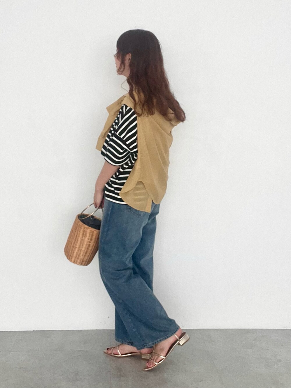 ブラック系のTシャツ/カットソー、イエロー系のシャツ/ブラウス、ブルー系のデニムパンツを着用したレディースの夏コーディネートの3枚目の写真