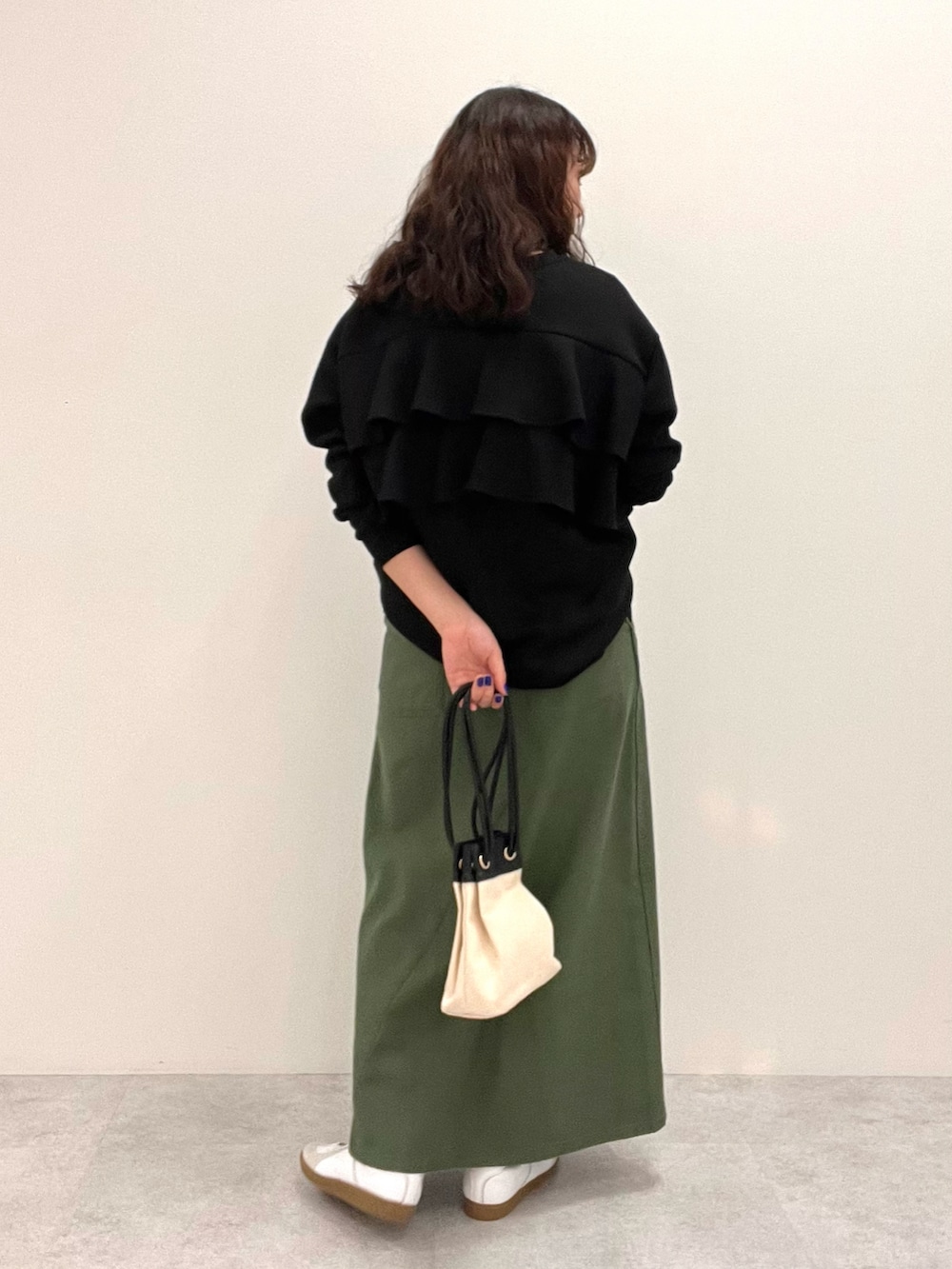 ブラック系のスウェット、グリーン系のスカートを着用したレディースの冬コーディネートの3枚目の写真