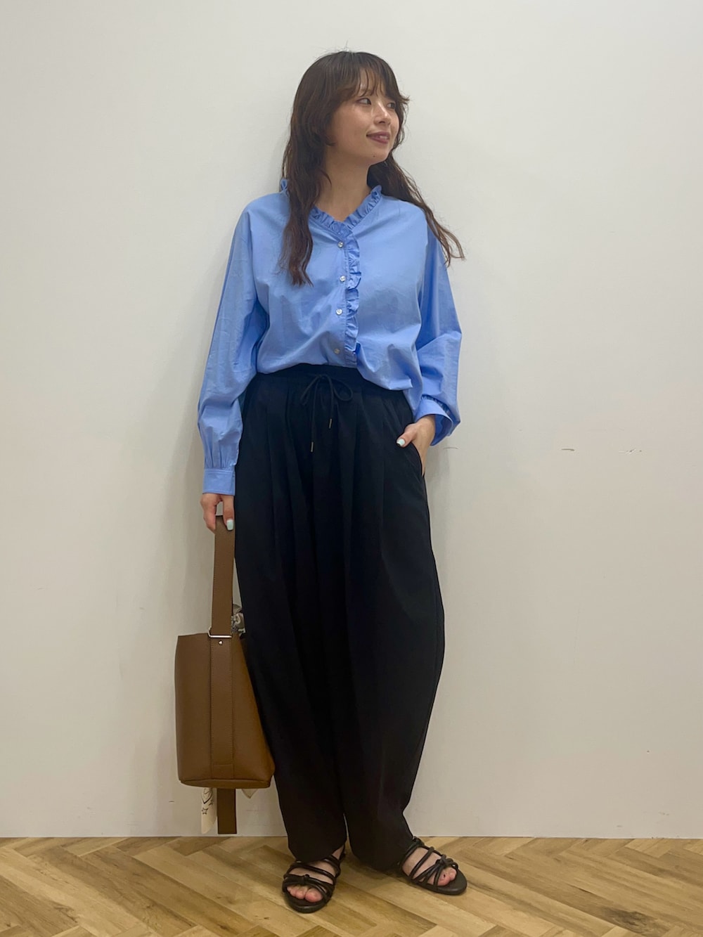 ブルー系のシャツ/ブラウス、ブラック系のその他パンツ、ブラウン系のショルダーバッグを着用したレディースの冬コーディネートの2枚目の写真