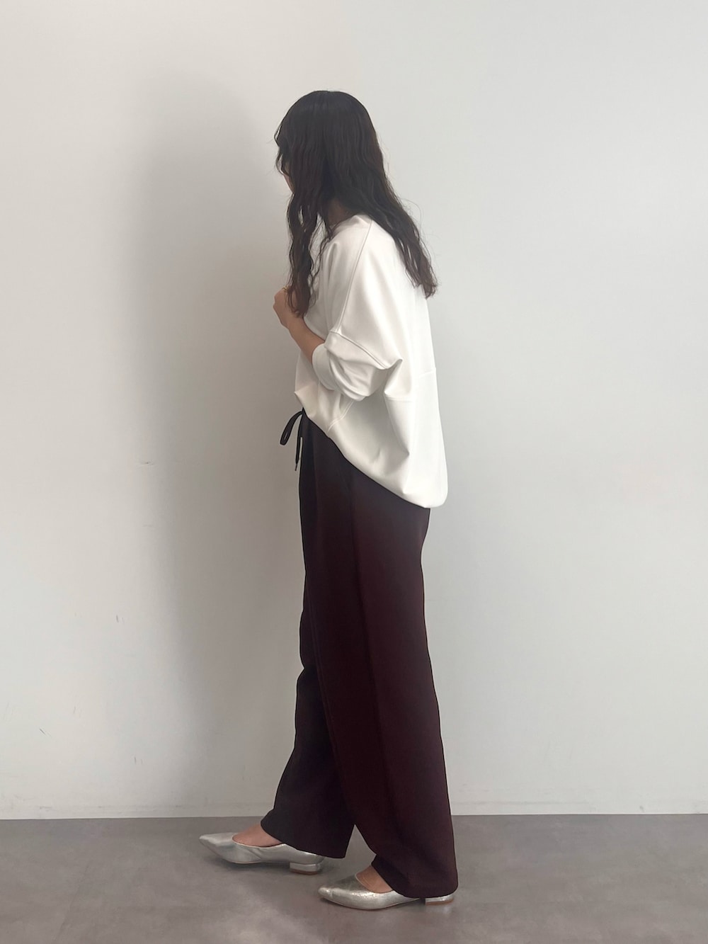 グレー系のスウェット、ブラウン系のその他パンツを着用したレディースの冬コーディネートの2枚目の写真