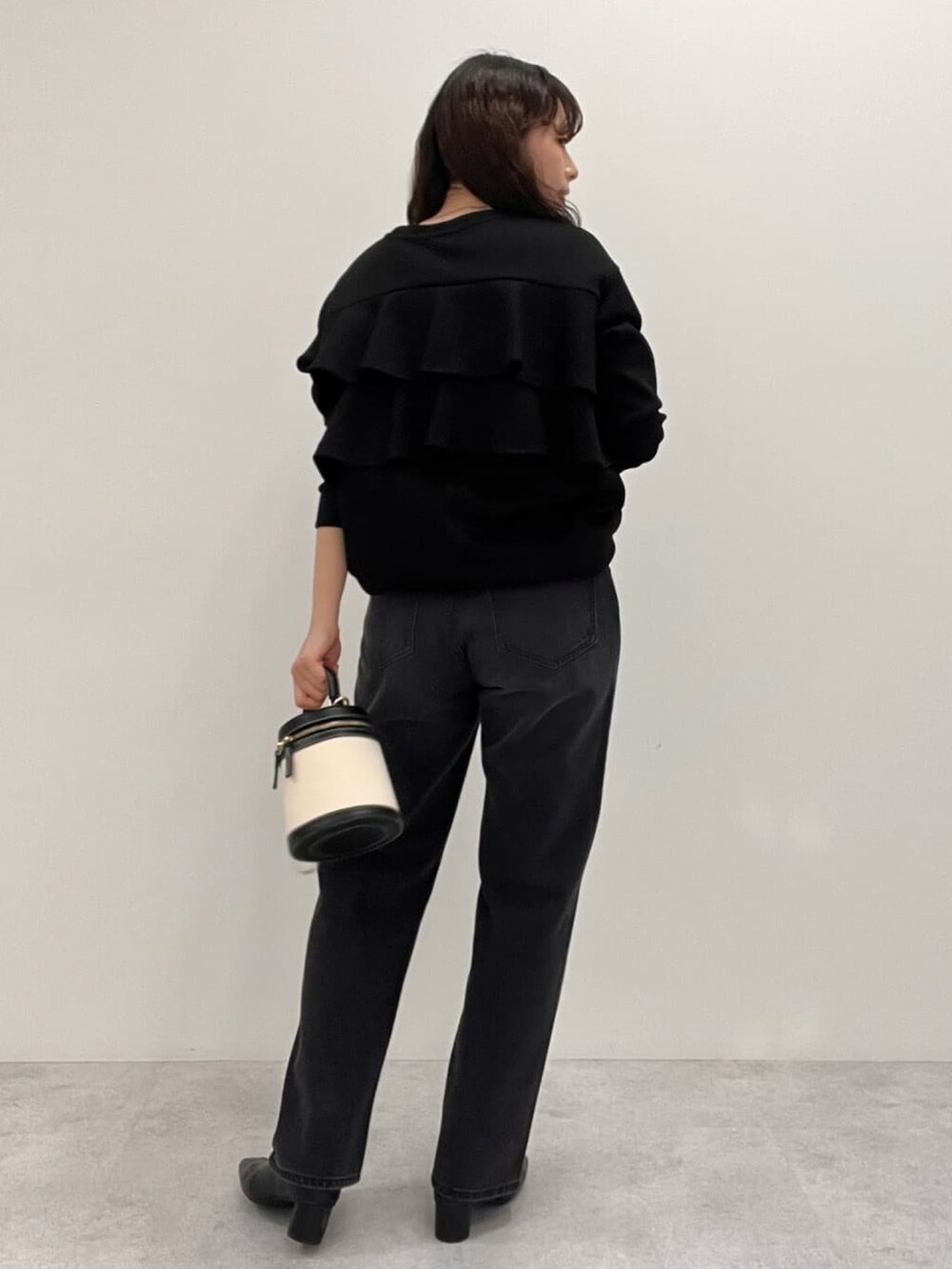 ブラック系のスウェット、ブラック系のデニムパンツを着用したレディースの冬コーディネートの4枚目の写真