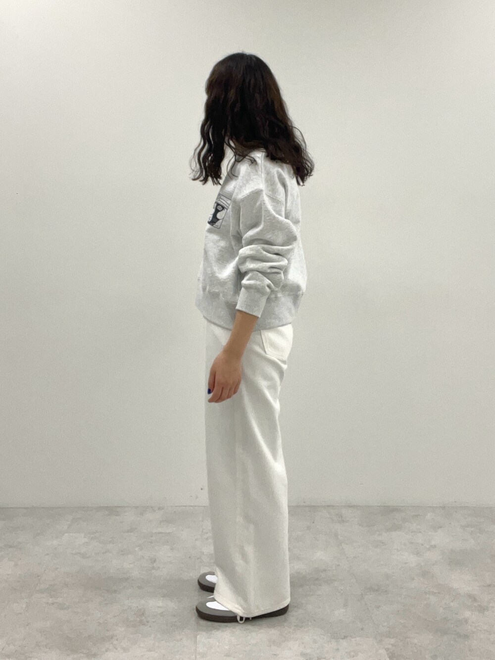 ホワイト系のスウェット、ホワイト系のデニムパンツを着用したレディースの冬コーディネートの3枚目の写真