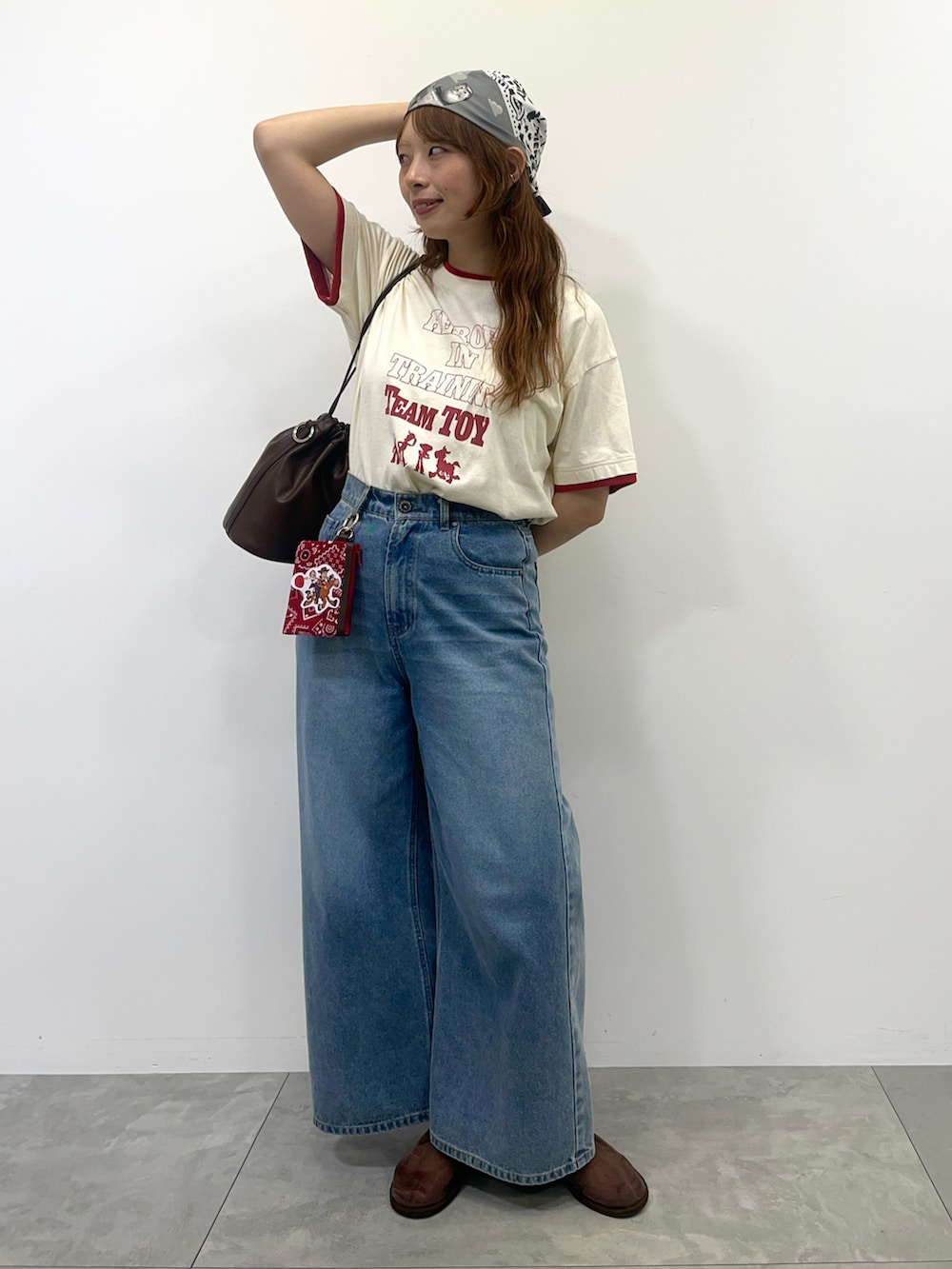 ブラウン系のショルダーバッグ、ブラウン系のその他シューズ、ホワイト系のTシャツ/カットソーを着用したレディースの夏コーディネートの2枚目の写真