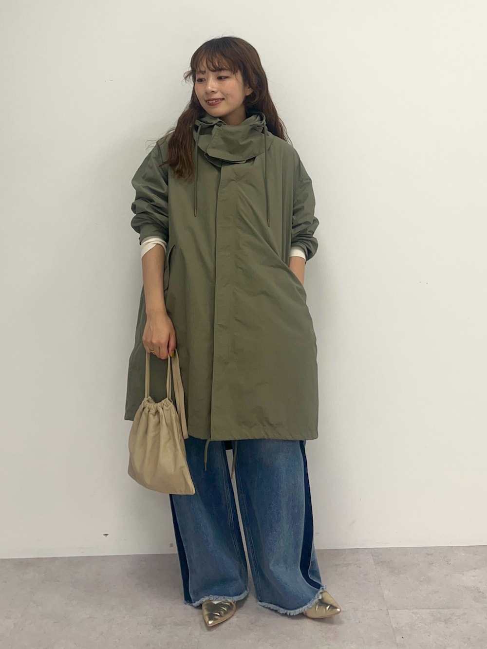 ブルー系のデニムパンツ、グリーン系のその他アウターを着用したレディースの秋コーディネートの2枚目の写真