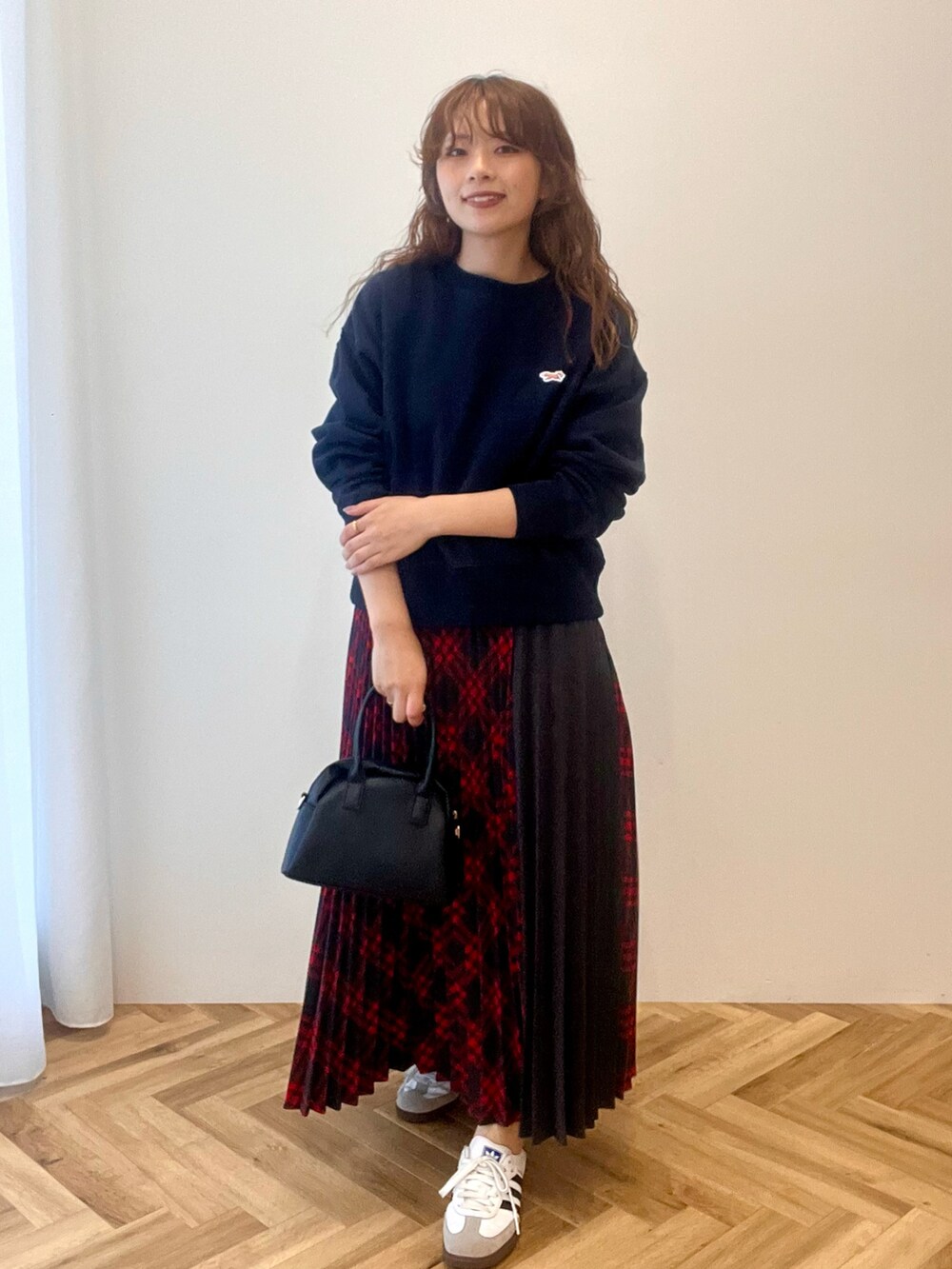 ブルー系のスウェット、レッド系のスカートを着用したレディースの秋コーディネートの2枚目の写真