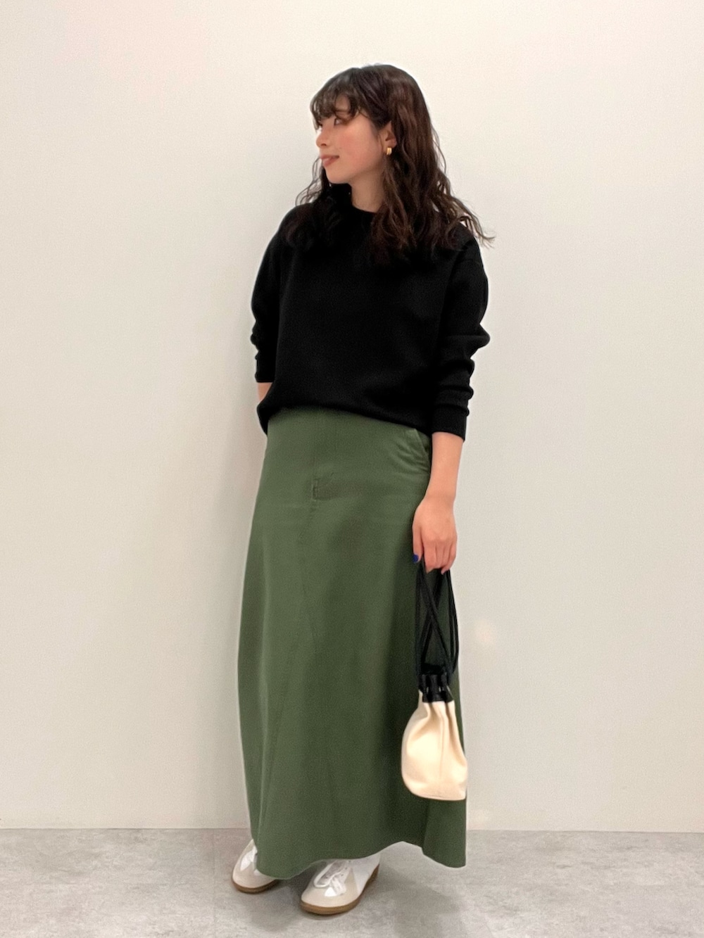 ブラック系のスウェット、グリーン系のスカートを着用したレディースの冬コーディネートの2枚目の写真