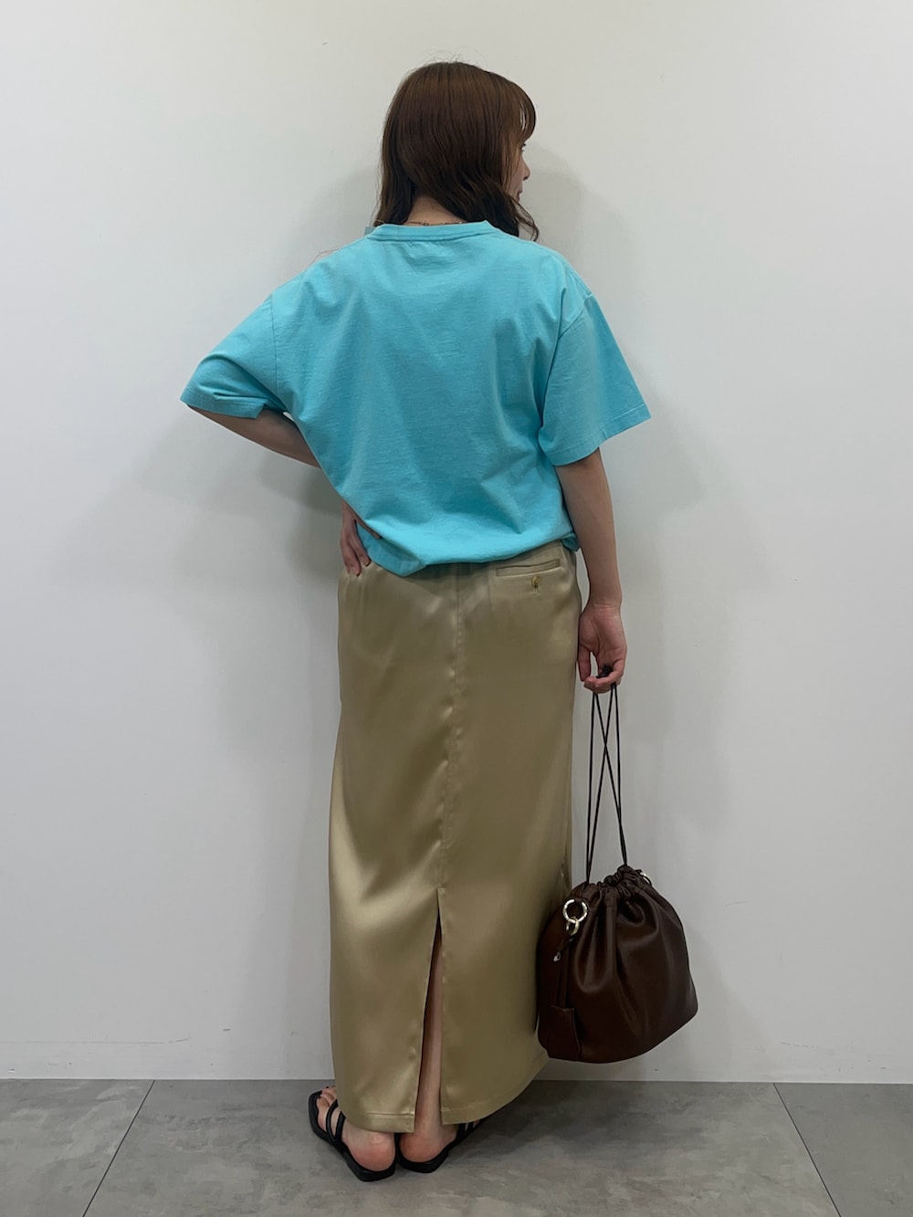 ブルー系のTシャツ/カットソー、ベージュ系のスカート、ブラック系のサンダルを着用したレディースの夏コーディネートの2枚目の写真