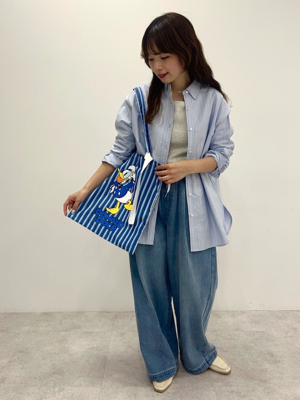 ブルー系のシャツ/ブラウス、ブルー系のデニムパンツ、ブルー系のトートバッグを着用したレディースの冬コーディネートの2枚目の写真